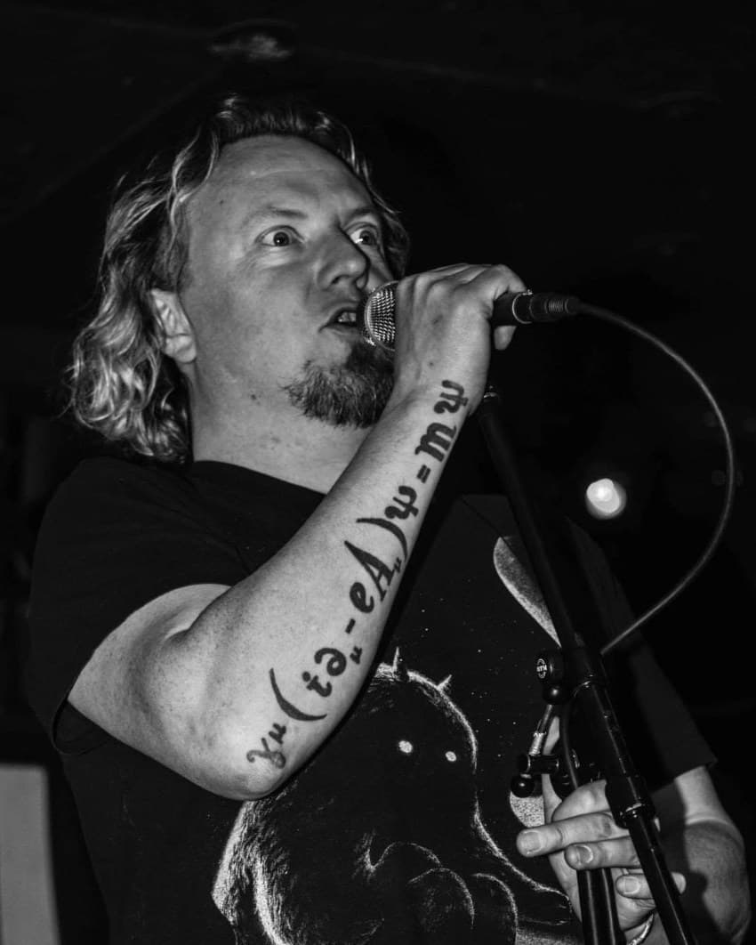 Neil Numb, founder and organiser of Berlin Chili Fest, singing into a microphone on stage.